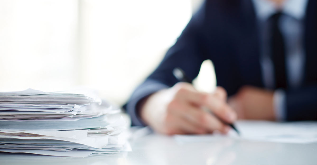Persona trabajando en unos documentos en una correduría especializada en barcos